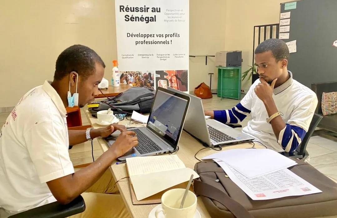 Deux développeurs de l'équipe YeminiCoder en session de travail sur leurs ordinateurs, à Dakar